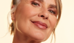 Woman with blonde hair and mauve lipstick smiling with her head tilted to her left